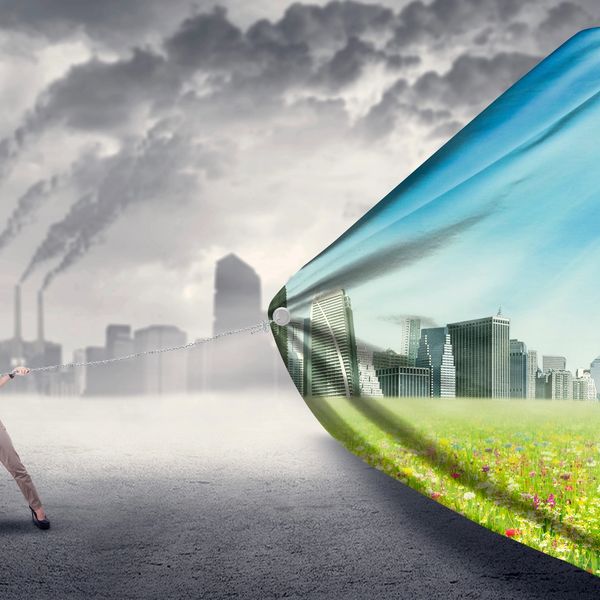 A woman pulls a chain to reveal a clean, green city behind polluted air and factories.