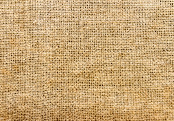 Close-up of natural burlap fabric texture with woven fibers.