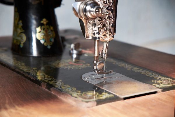 Close-up of a vintage sewing machine needle and base with intricate designs.