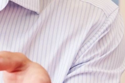 Person in a striped shirt extending a hand forward.