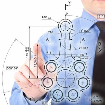Engineer points at a detailed technical drawing of a mechanical part.