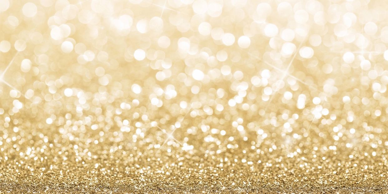 Shimmering golden glitter background with soft bokeh lights.