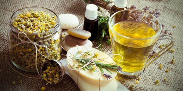 Flower buds, soap, herbs and oil on a cloth.