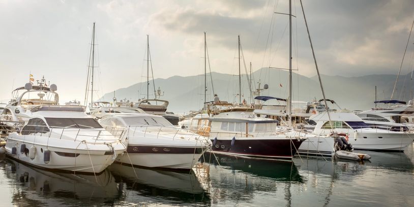Luxury yachts docked peacefully in a marina at sunset.