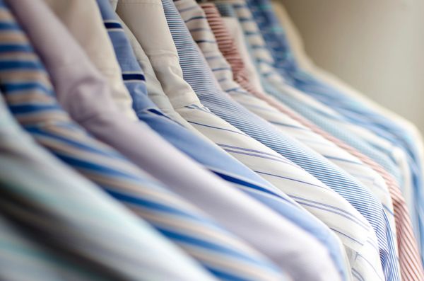 a row of hanging dry-cleaned shirts. Easy Breezy Laundromat. Laundromat near me, Coin laundry near