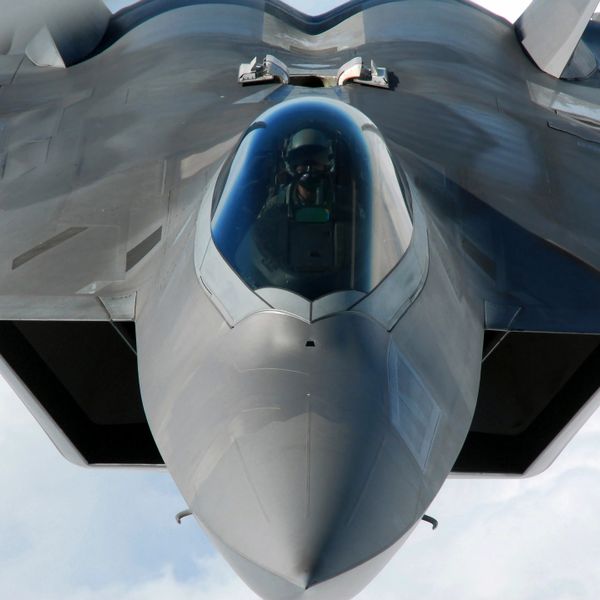 Front view of a stealth fighter jet with pilot inside the cockpit.
