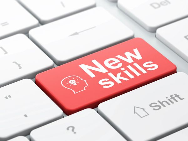 Keyboard with a red key labeled 'New skills' symbolizing learning and growth.
