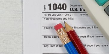 Close-up of a 1040 tax form with pencils and calculator.