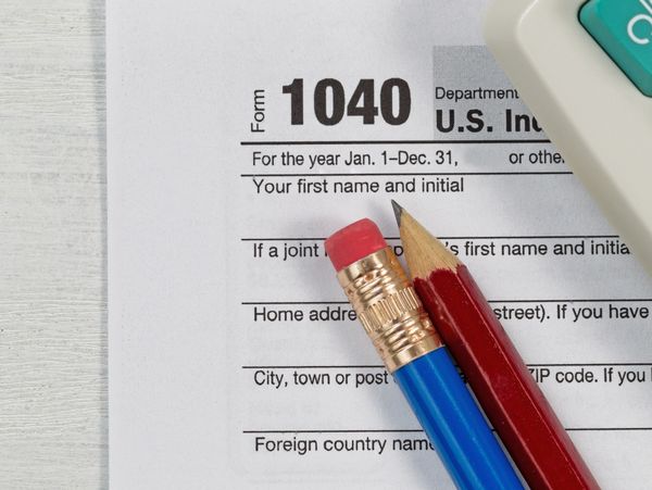A U.S. tax form 1040 with pencils and a calculator.