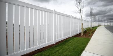 Small White picket fence on new home build with freshly laid grass and small tree