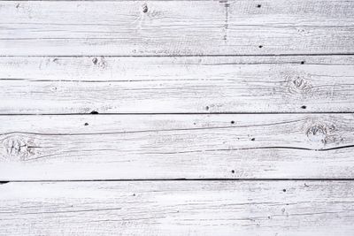 White painted wooden planks with visible grain and knots.