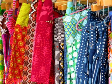 Colorful patterned fabrics hanging on a rack.