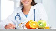A doctor with a stethoscope and fresh fruits promoting healthy living.