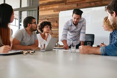 group of people sitting around table having a meeting