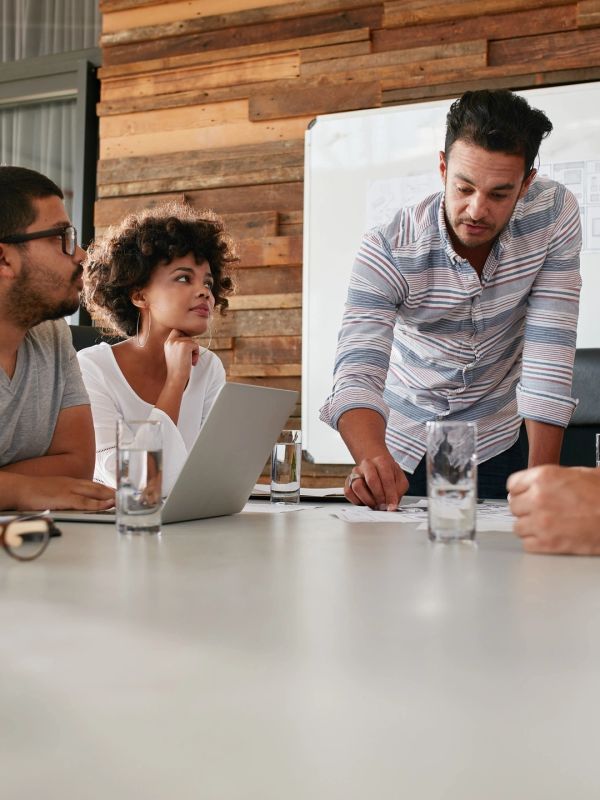 Team discussing ideas around a table in a modern office.