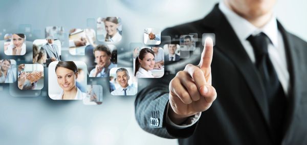 Businessman selecting digital profile images on a virtual interface.