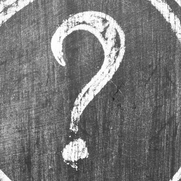 White question mark on a textured black surface.