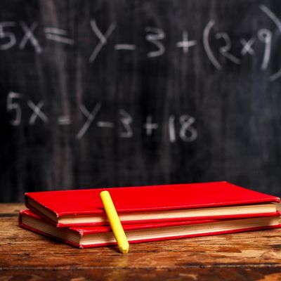 blackboard with algebra equations, books, and pencil