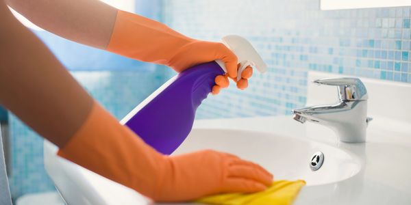 House keeper cleaning and disinfecting a sink