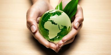 Earth, environment, climate change, ecology, nature. Hands holding green globe and leaves.