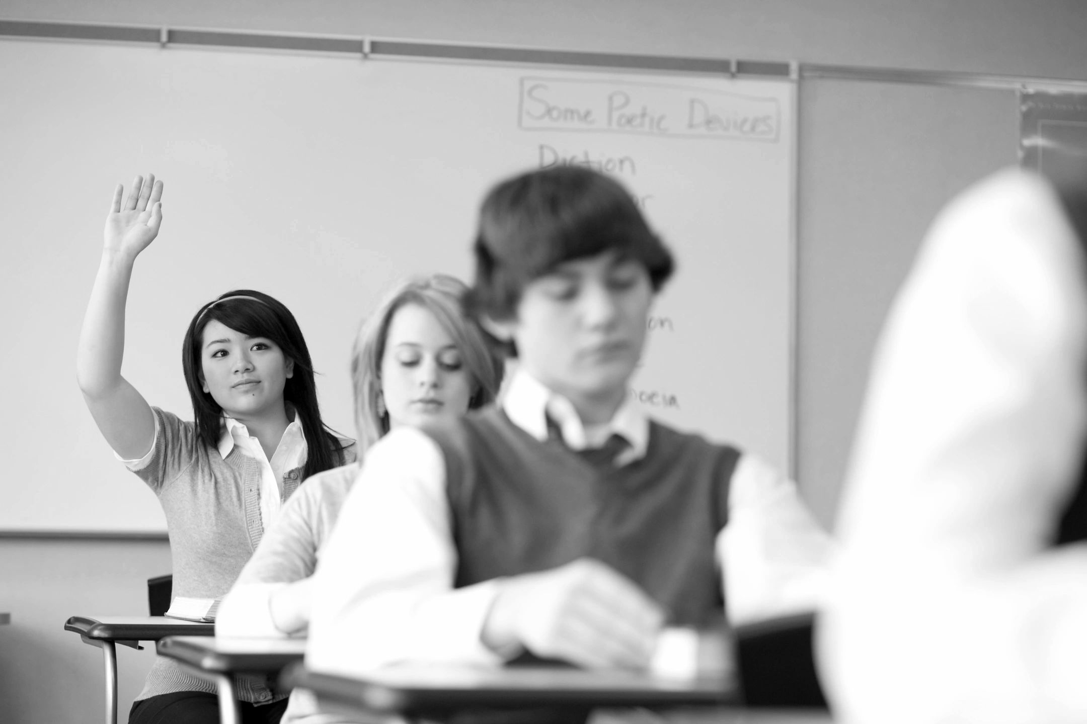 few school students with 1 student with raised hand
