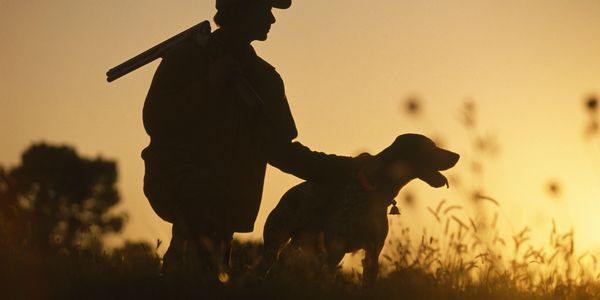 Arizona quail hunting guide with his pointing dog at sunrise.
