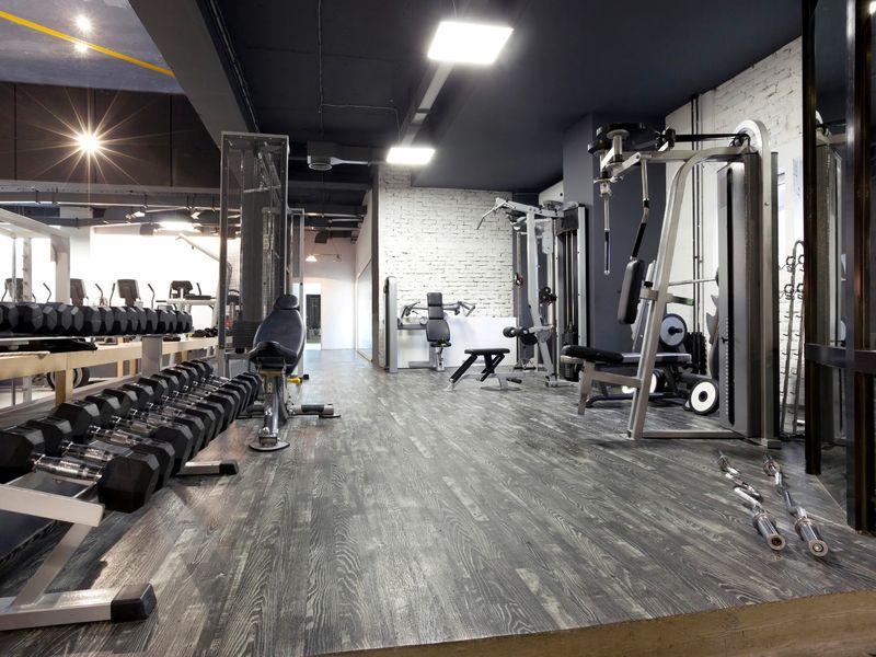 Modern gym interior with various workout equipment and dumbbells