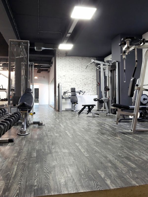 Modern gym with various workout machines and weights in a spacious room.
