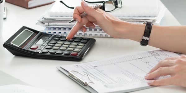 Person using calculator to file their taxes.