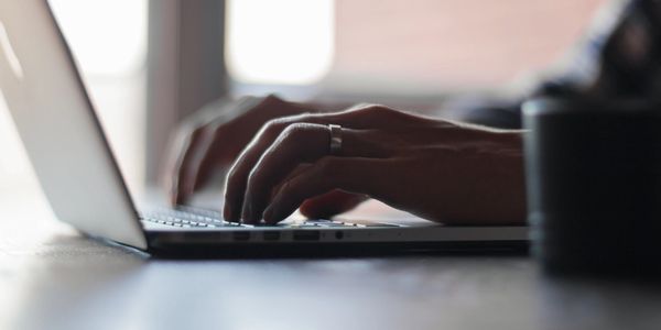 a man typing with a laptop keyboard 