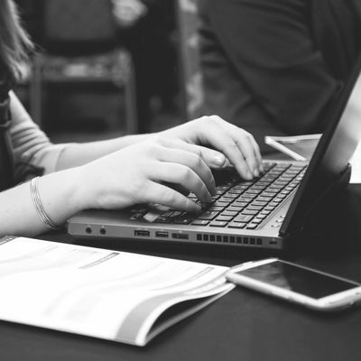 Hands typing on a laptop