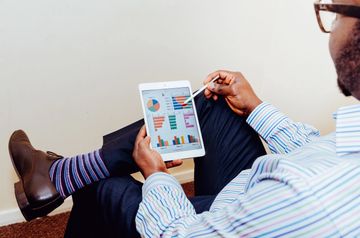 Man analyzing charts on a tablet.