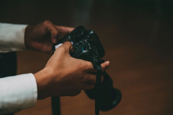 Person holding a DSLR camera.