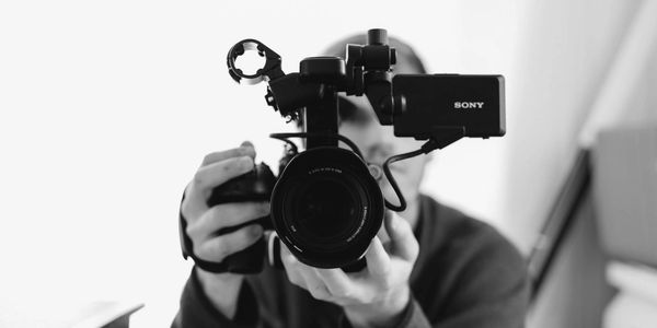 Person holding and filming with a Sony video camera.