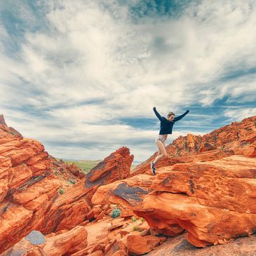 A woman jumping from one stone to another