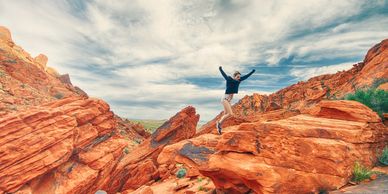 man joyfully at the top of a rock structure