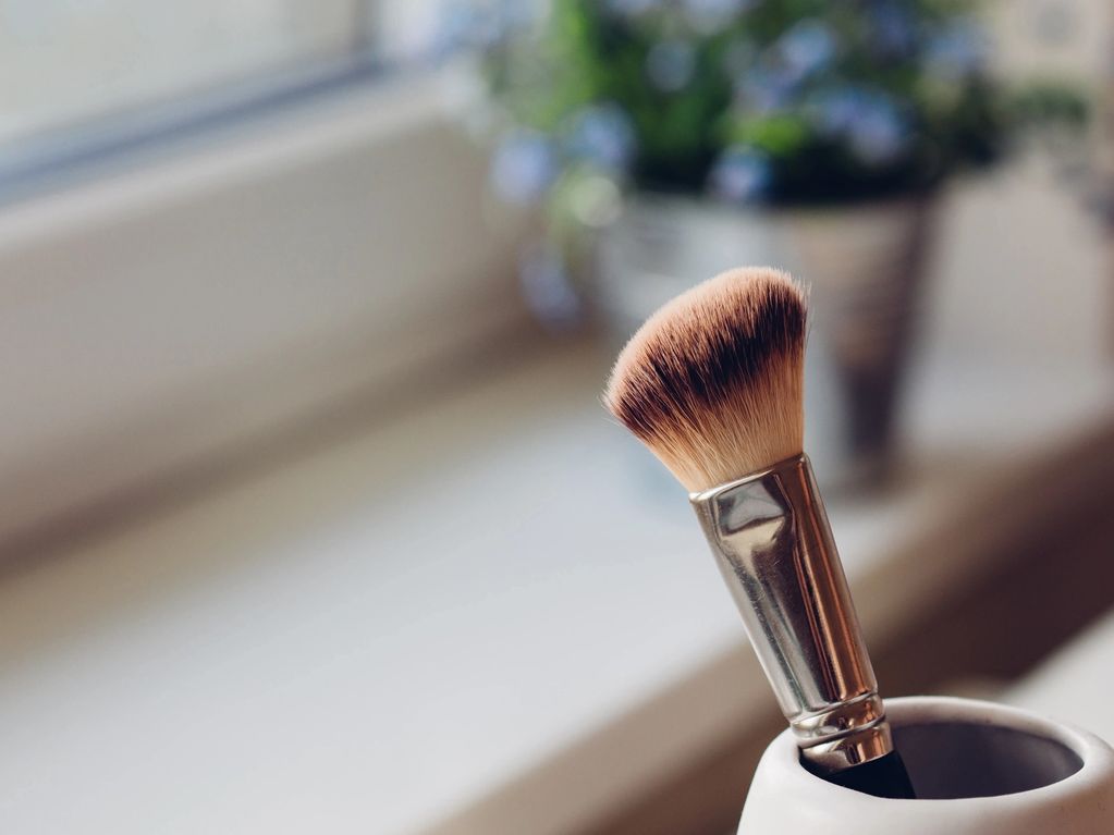 Brocha de maquillaje en un recipiente.
