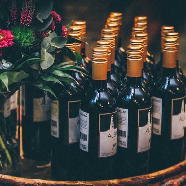 Wine bottles nestled next to a floral bouquet 