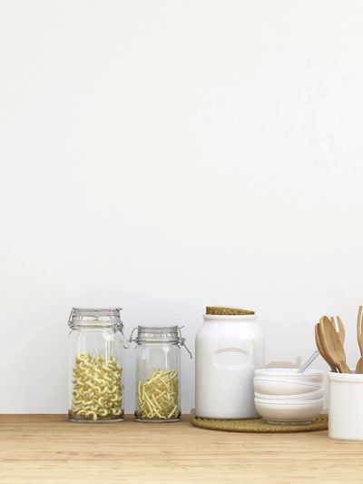 Minimalist kitchen counter with jars, bowls, and wooden utensils.