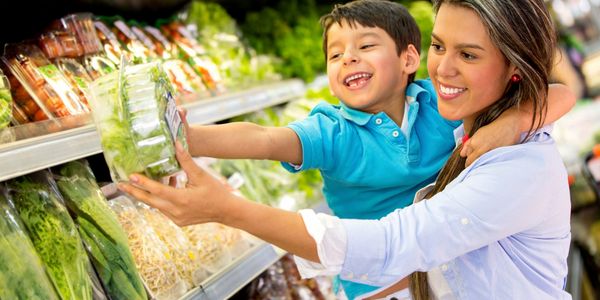 Mother and son lookin at fresh produce in the store