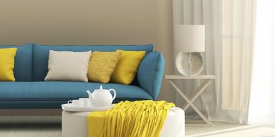 Modern living room with blue sofa and yellow accents.