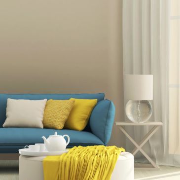 Cozy living room with blue sofa and yellow accents.