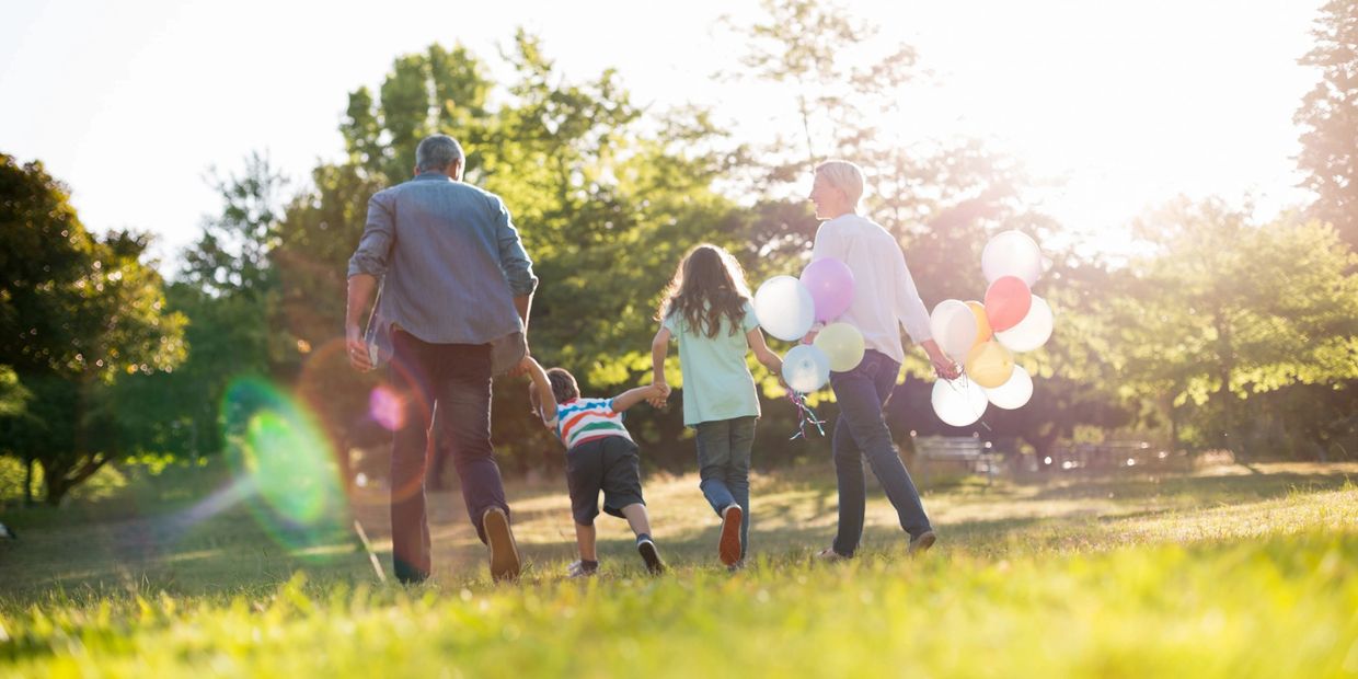 Family of 4 enjoying a park on a sunny day.