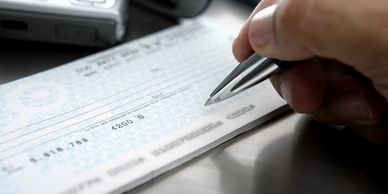 person writing cheque for payment option 