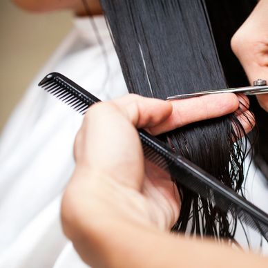 Close-up of a haircut with scissors and comb on wet hair.