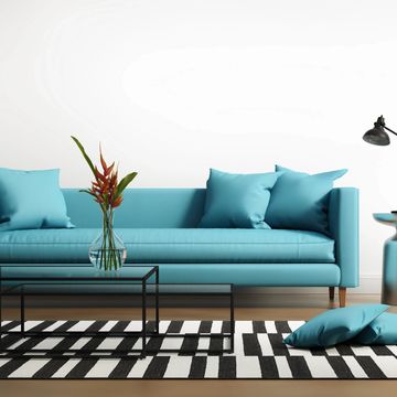 Modern living room with a blue sofa and black-and-white rug.