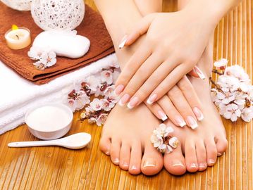 A pair of hands on top of feet, with blossoms.