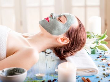 A woman relaxing with with a mask on her face.