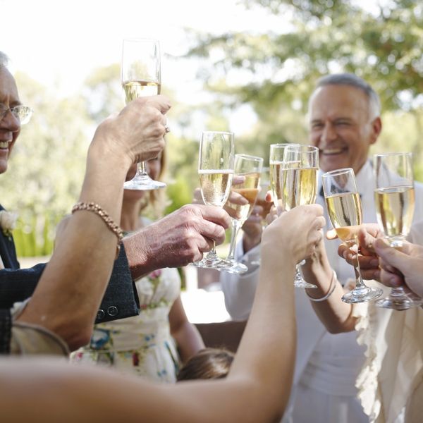 Group of people toasting with champagne glasses outdoors.