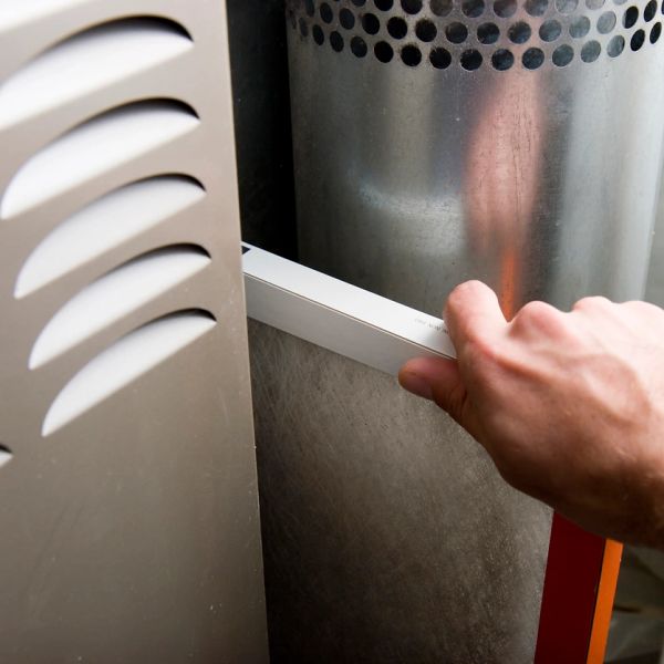 Hand inserting or removing an air filter from a metal appliance.